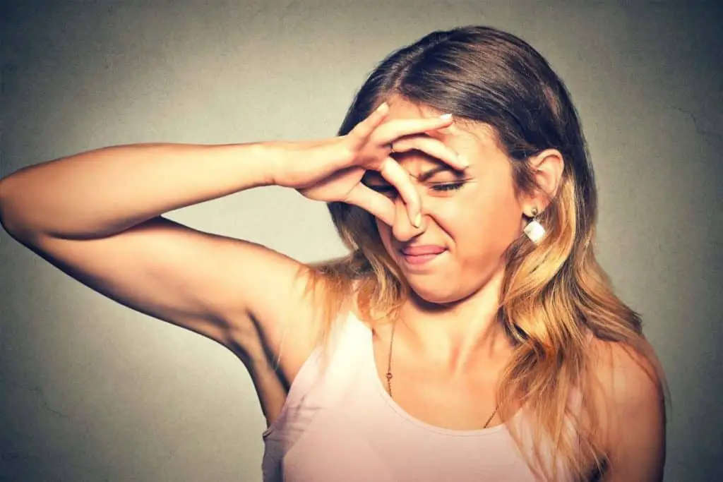 Image of lady holding her nose while smelling a stinky rabbit